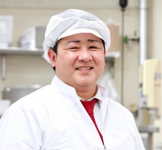 白い調理服で笑顔を見せるスタッフ