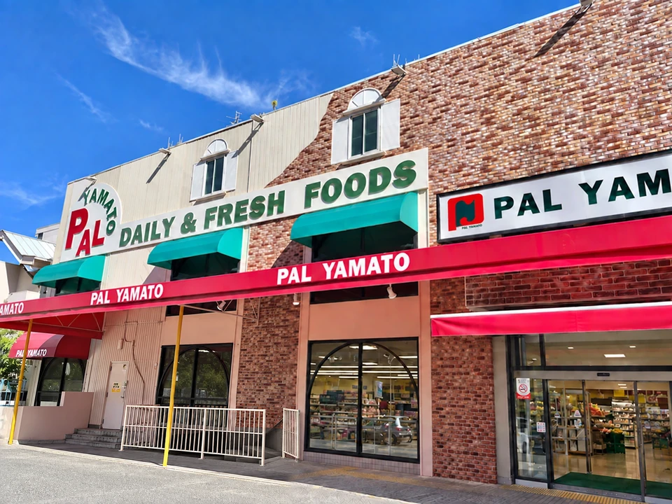 青木店の外観。DAILY & FRESH FOODSの看板と赤いテント