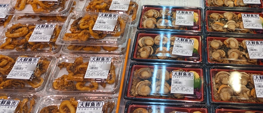 六甲店の惣菜売場に並ぶするめいか唐揚げやほたて照焼重