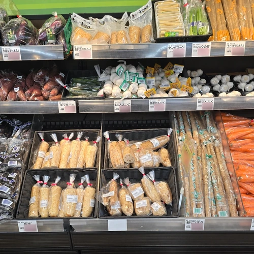 六甲店の農産売場に並ぶ長芋やごぼう、にんじん等の根菜類