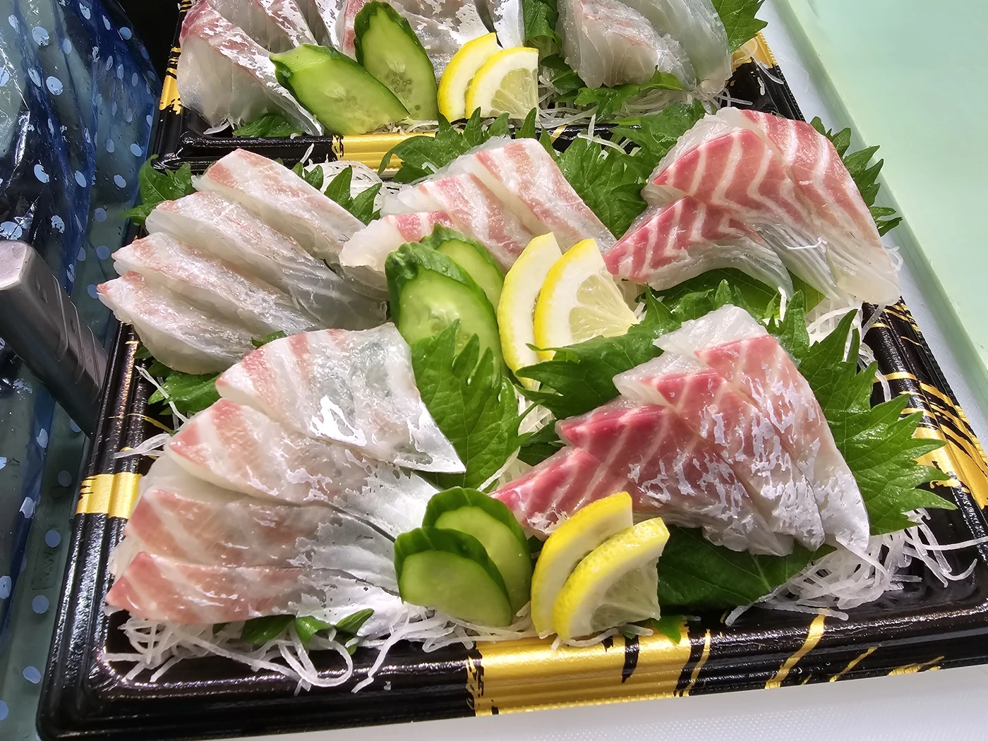 夙川店の刺身盛り合わせ。白身の切り身に大葉、きゅうり、レモンを添えた一皿。