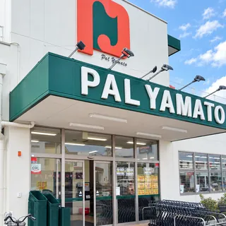 白い外壁と緑の看板の店舗外観