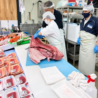 水産売場でマグロをさばくスタッフ